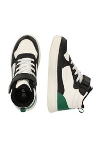 Sorte og hvide højhælede sneakers med grønne detaljer, der har en struktureret overflade, snørebånd og en velcro-rem for ekstra støtte.