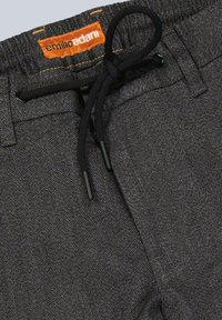 Graue Jogginghosen aus strukturiertem Stoff. Mit einem gewebten Etikett in Orange. Enthält einen schwarzen Kordelzug und Metallspitzen zur Anpassung.