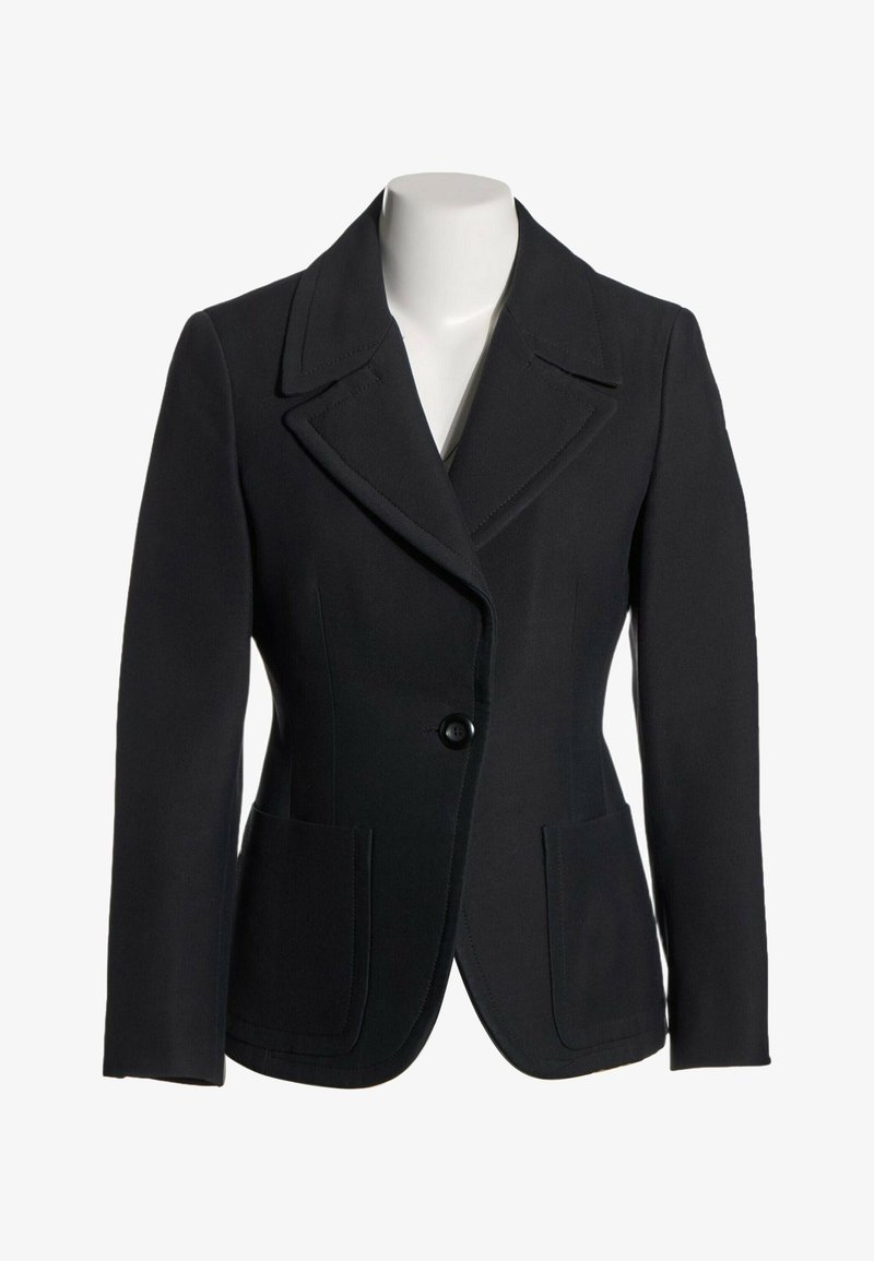 Blazer noir à un seul bouton avec larges revers et deux poches avant sur un mannequin blanc sans tête.