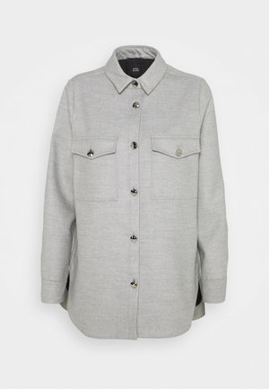 Chaqueta camisa gris claro con dos bolsillos en el pecho, cuello y mangas largas, mostrada sobre un fondo blanco.