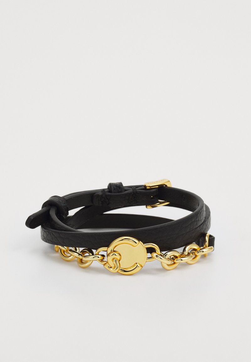 Pulseira de couro preta com um detalhe de corrente dourada e um fecho circular em ouro. O design inclui duas tiras de couro sobrepostas.