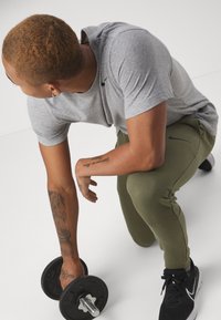 Nike Performance TAPER - Pantalones deportivos - medium olive/black