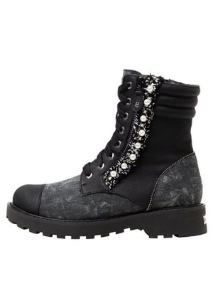 Botte de combat noire et grise avec fermeture éclair latérale, lacets, semelle épaisse, cheville rembourrée et bordure décorative en perles le long de la ligne de la fermeture éclair.