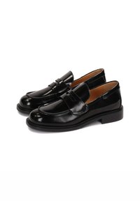 Mocasines de cuero negro con un acabado brillante, que presentan un diseño aerodinámico, detalle de tira en la parte delantera y un tacón sólido bajo.