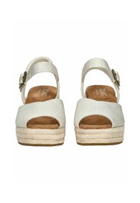 Bílé espadrilky s otevřenou špičkou, přírodní jutu podpatkem a textilním páskem. Nastavitelný pás na kotníku s kovovou sponou.