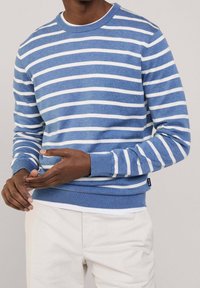 Modrý a bílý pruhovaný svetr s kulatým výstřihem, dlouhými rukávy, žebrovanými manžetami a spodním lemem. Tkanina působí měkce a strukturovaně.