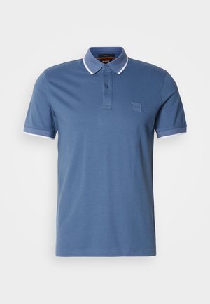 Blue polo shirt made of cotton. Features a classic collar, two-button placket, and contrasting white accents on sleeves. Small branded patch.
