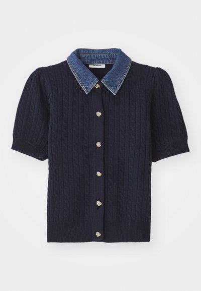 Navy knitted sweater with short puff sleeves, featuring a denim collar and gold button accents down the front. Cable knit texture throughout.
