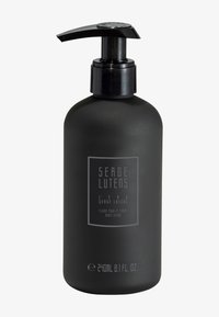 Bottiglia nera opaca con un tappo a pompa, con un'etichetta trasparente che riporta la dicitura "Serge Lutens" e dettagli sulla crema per il corpo, 240 ml.