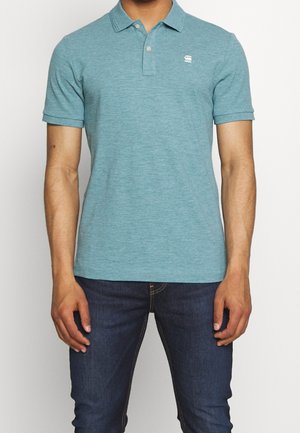 Tyrkysová polokošile s límečkem, krátkými rukávy a malým logem na levé straně hrudi. Vyrobená z texturované, lehké tkaniny.