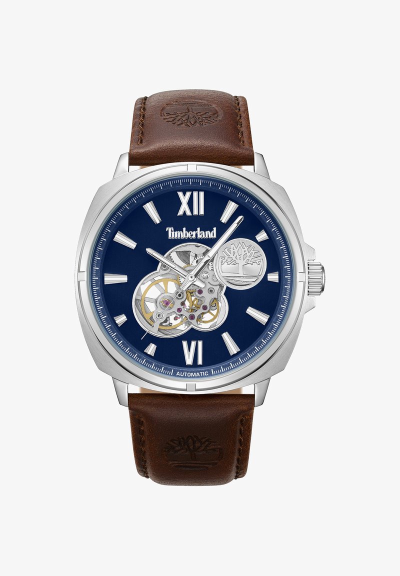 Montre automatique Timberland avec boîtier en acier inoxydable argenté, cadran bleu, chiffres arabes et bracelet en cuir marron arborant un logo.