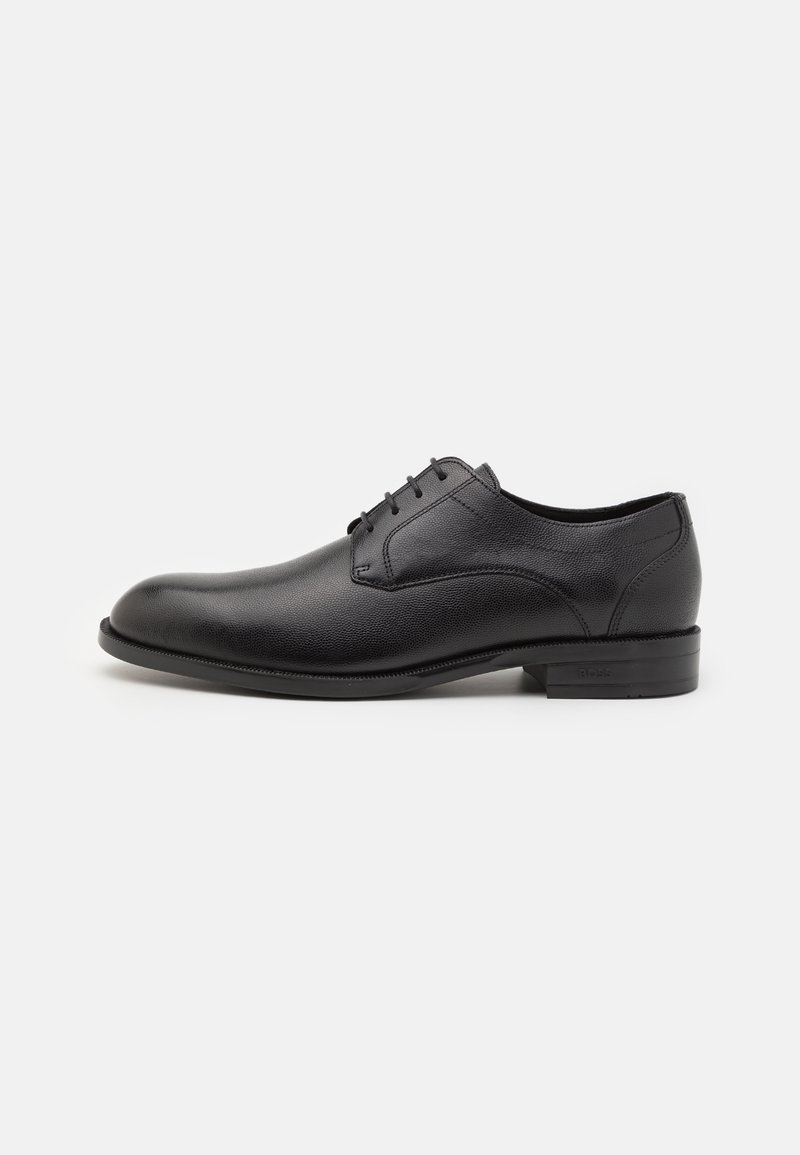 Chaussure habillée en cuir noir avec une texture lisse, bout arrondi, fermeture à lacets à cinq œillets et un petit talon empilé. Semelle avec un motif d'adhérence minimal.