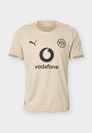 Tricou sport de culoare bej, cu mâneci scurte, având logo-ul negru Puma, emblema BVB 09 și logo-ul sponsorului Vodafone pe partea din față.