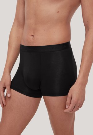 Boxers en coton noir avec une coupe ajustée, présentant une texture lisse et une taille douce embossée du nom de la marque.