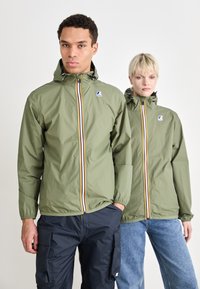 Giubbotti windbreaker in verde oliva, con cerniera a strisce multicolori, cappucci regolabili e polsini elasticizzati. Tessuto strutturato e leggero.