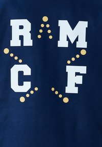 Mornarsko modra bombažna majica z izrazitimi belimi črkami "R", "M", "C", "F" in rumenimi pikami, ki so razporejene v diagonalnih vzorcih.