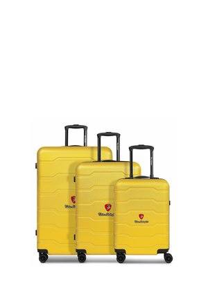 Yellow hard-shell luggage set, three sizes, textured surface, black handles, and wheels. Features logo on front.