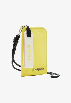 Geel nylon schoudertas met ritssluiting, zwarte strap en crèmekleurige accenten met de merknaam "Desigual" in zilveren letters.