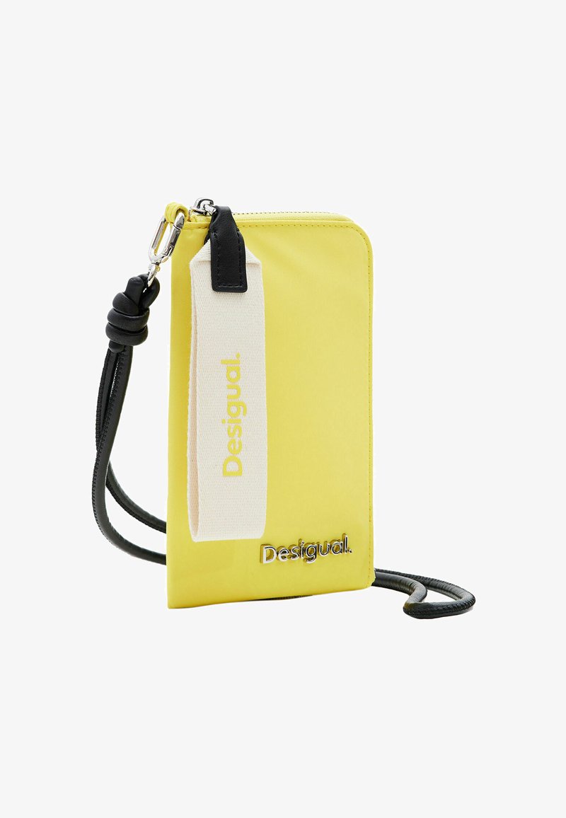 Geel nylon schoudertas met ritssluiting, zwarte strap en crèmekleurige accenten met de merknaam "Desigual" in zilveren letters.