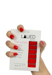 Rote Nagellackwickel in einer rechteckigen Verpackung mit weißem Hintergrund. Enthält Anweisungen für eine einfache Anwendung und Entfernung. Vegan, ohne Tierversuche.