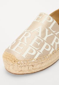 Espadrille color beige chiaro con motivi a logo in rilievo, suola in juta intrecciata e parte superiore in tessuto liscio con design slip-on.