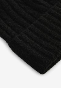 Zwarte gebreide muts met een ribbelstructuur, gemaakt van een dikke, zachte stof. De rand is omgevouwen en toont het dichte weefpatroon.