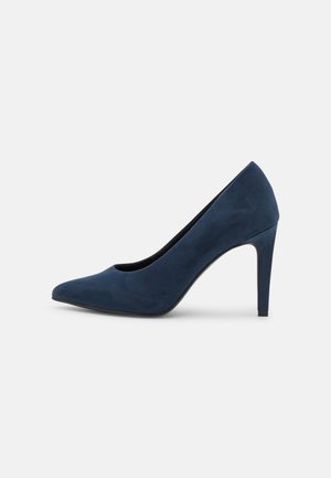 Marineblå højhælet pumpe med spids snude og slank stiletthæl, vist fra siden på en ensfarvet baggrund.