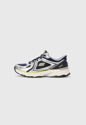 Navy and silver athletic shoe with mesh upper, reflective accents, padded collar, and rubber sole with green details.