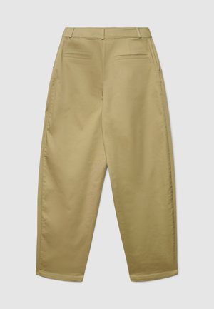Pantaloni kaki a vita alta con vestibilità comoda. Presentano due tasche posteriori e una texture liscia. Davanti ci sono passanti per la cintura; i polsini sono leggermente stretti.