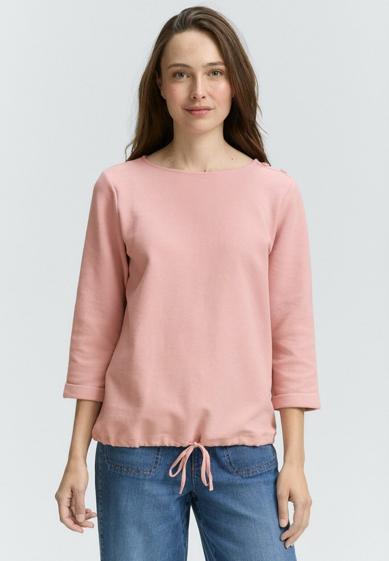 Helles rosa, langärmliges Oberteil aus Baumwolle mit Rundhalsausschnitt, Kordelzug in der Taille und Knopfakzenten an den Schultern. Lässige Passform und Textur.