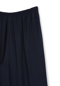Pantaloni larghi blu navy con elastiche in vita. Realizzati in un tessuto leggero con una texture morbida e pieghe sottili.