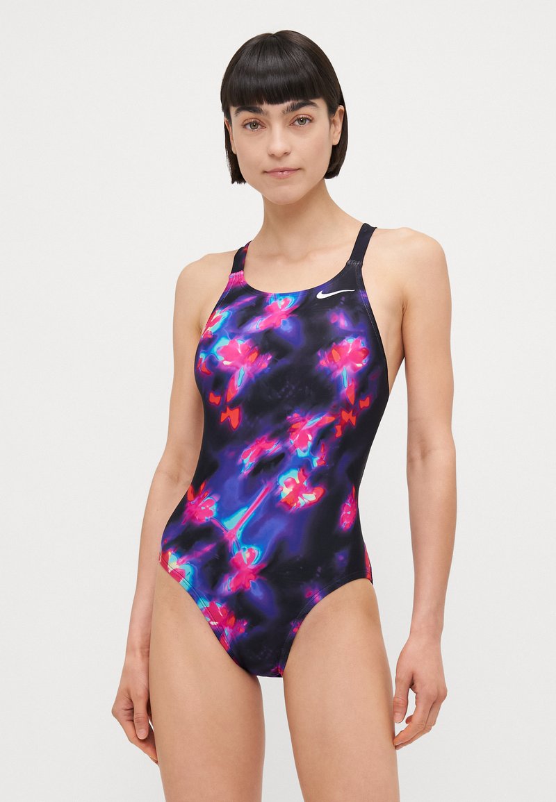 Costume intero Nike caratterizzato da una base nera con vivaci motivi floreali rosa e viola, design a schiena scoperta e una trama liscia e lucida.