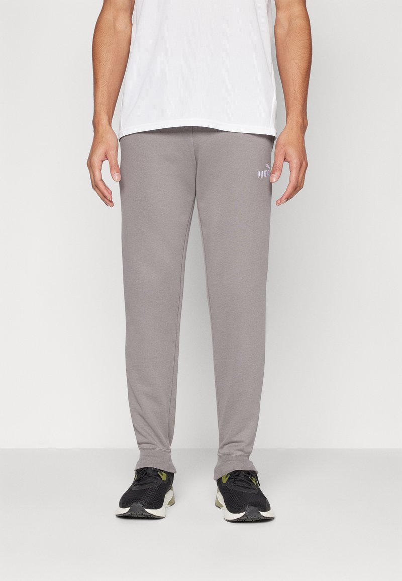 Grijze sweatpants van zachte stof, met een aangesloten pasvorm en een klein wit Puma-logo op de linker dij. Afgewerkt met ribgebreide manchetten.