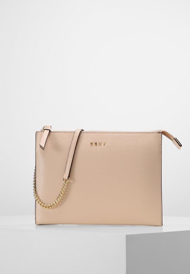 Beige leather handbag with gold chain strap and embossed logo. Smooth texture, rectangular shape, and minimalistic design.