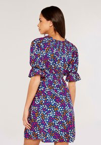 Blumenkleid mit blauem Hintergrund und mehrfarbigen Mustern in Pink, Orange und Weiß. Kurze Puffärmel und taillierte Taille.