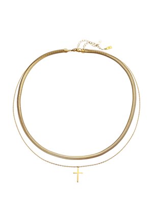 Nahaufnahme des Halses eines Mannes, der eine strukturierte goldene Halskette und ein weißes geripptes Tanktop trägt.