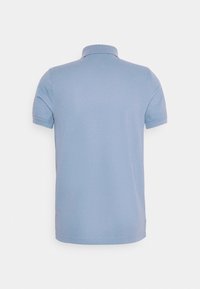 Polo bleu clair à manches courtes vu de dos avec un col côtelé et un tissu uni.