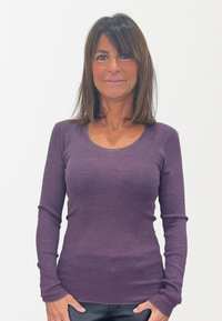 Maglietta a maniche lunghe a coste di un profondo viola, con scollo a barca e una silhouette aderente, realizzata in un tessuto morbido ed elasticizzato.