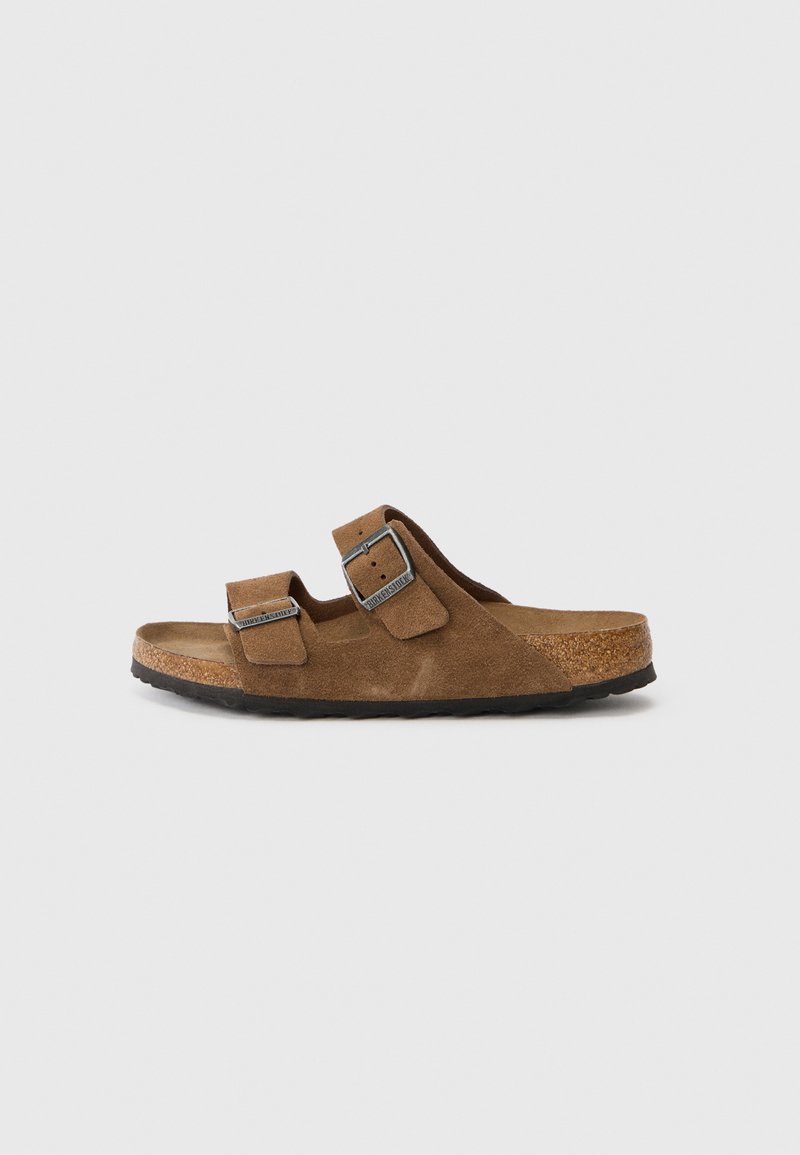 Hnědé suede sandály s dvěma nastavovacími popruhy, korkovou stélkou a strukturovanou černou gumovou podešví. Jednoduchý design s kovovými přezkami.