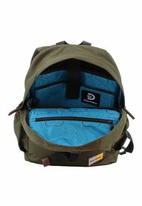 Zaino verde oliva con un interno a motivi blu. Presenta una tasca con cerniera frontale, etichetta con logo e spallacci regolabili. Tessuto resistente e design strutturato.