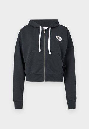 Cropped black hoodie made of soft cotton, featuring a front zipper, white drawstrings, a kangaroo pocket, and a circular logo patch.
