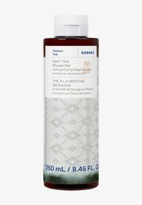 Brązowa butelka żelu pod prysznic Korres Miętowa Herbata z teksturowaną szaro-skalną etykietą, z białym napisem i niebieskimi akcentami. Pojemność wynosi 250 ml.