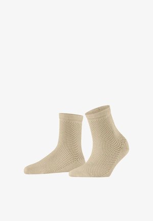 Een paar beige enkellange sokken met een fijnmazig breipatroon, naast elkaar geplaatst op een witte achtergrond.