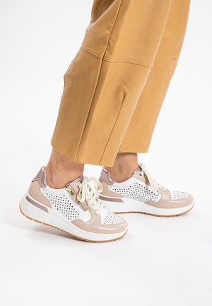 Sneaker mit einem weißen perforierten Obermaterial, beige Lederakzenten und cremefarbenen Schnürsenkeln, ausgestattet mit einer klobigen weißen Sohle und einer strukturierten braunen Unterseite.