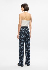 Pantalons de détente évasés noirs avec des motifs célestes bleu clair, fabriqués dans un matériau texturé, avec une ceinture élastique confortable.