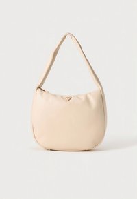 Borsa a mano in pelle beige con forma arrotondata, una tracolla singola e un dettaglio logo in tonalità oro sul davanti. Texture liscia e design minimalista.