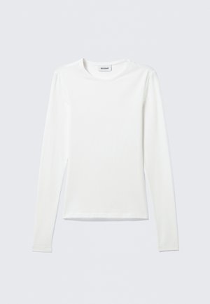 Long-sleeve white shirt made of soft fabric, featuring a round neck and straight hem. Minimalistic design with no visible patterns or accents.