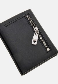 Portafoglio neroTexturizzato con chiusura a cerniera laterale, dotato di accessori in argento e del nome del marchio impresso sul tirante della cerniera.