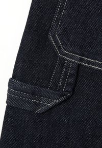 Tela de denim azul oscuro con costuras blancas y un detalle destacado en el bolsillo. La textura parece resistente con un acabado suave.