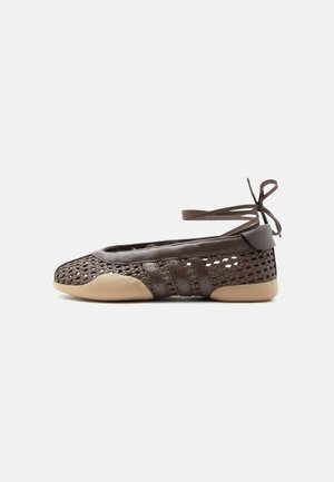 Brauner gewebter flacher Schuh mit beiger Sohle und Fußgelenkband, mit Lederüberzügen und offen gewebtem Design an den Seiten und der Spitze.